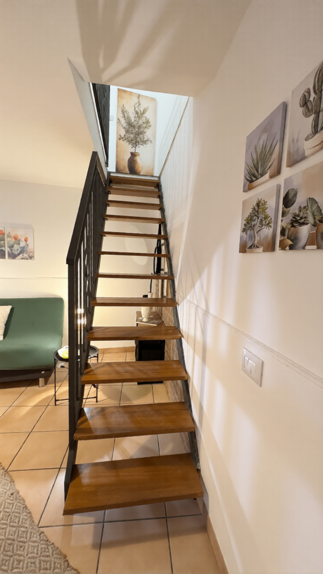 Scala interna di Bedda Matri con struttura in ferro nero e gradini in legno massello che collega zona giorno e camera al piano superiore